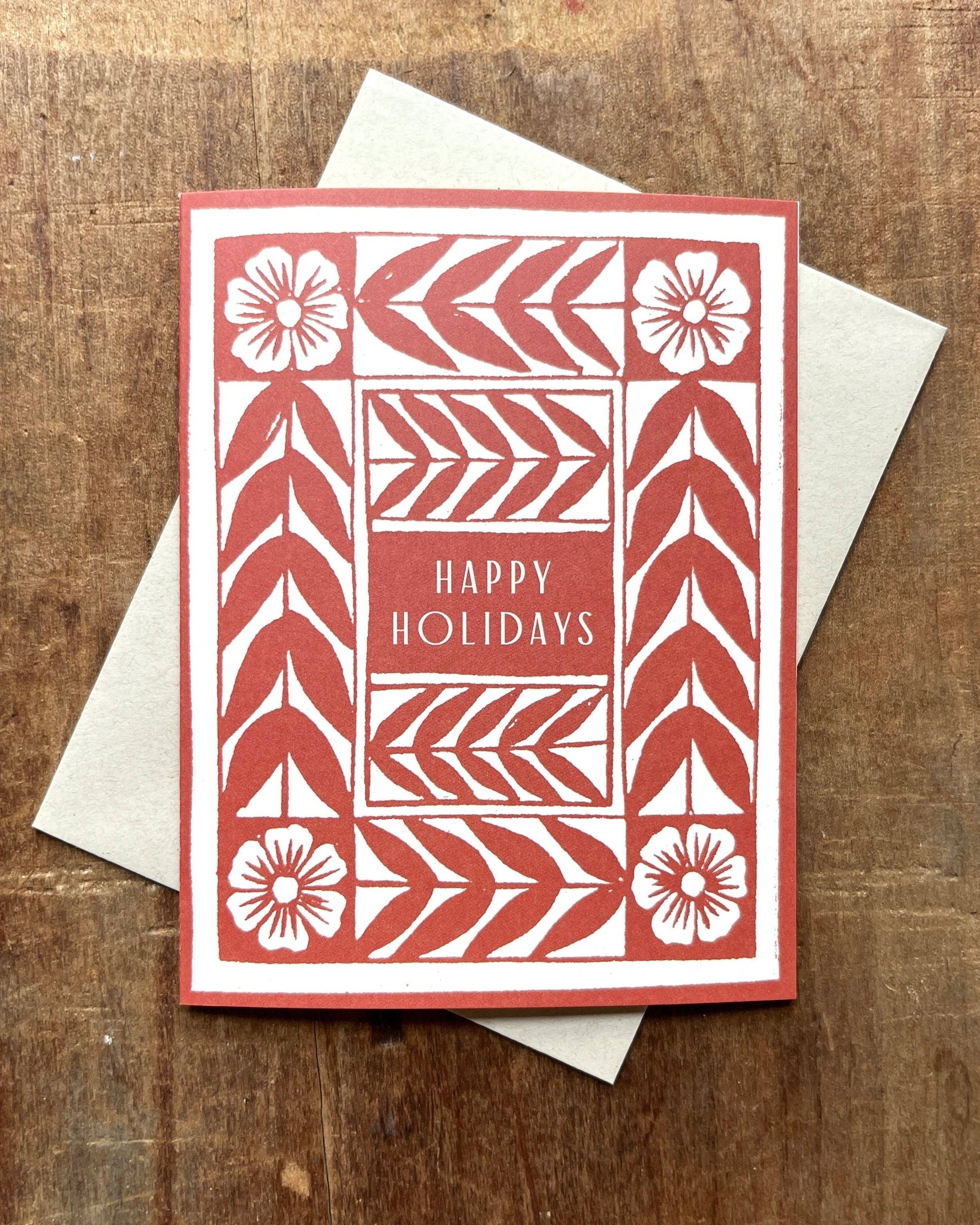 Red and white holiday card with geometric and floral patterns with text Happy Holidays
